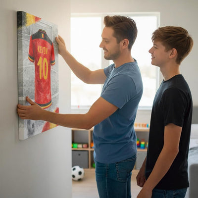 Accrochage au mur d'une toile canvas au maillot de la Belgique personnalisé : nom floqué en capitales et numéro, rendu aquarelle aux couleurs du pays, livrée (exemple)
