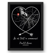 Affiche couple : carte noire aux routes blanches dans un cœur cerné de blanc sur fond noir, flèches croisées, épingle rouge, phrase, prénoms et date, en cadre noir livrée chez vous (exemple)