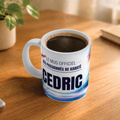 Café fumant dans le mug karaté posé sur un bureau en bois : la phrase « Le mug officiel des passionnés de karaté » et son prénom en grandes capitales, mug livré chez vous (exemple)
