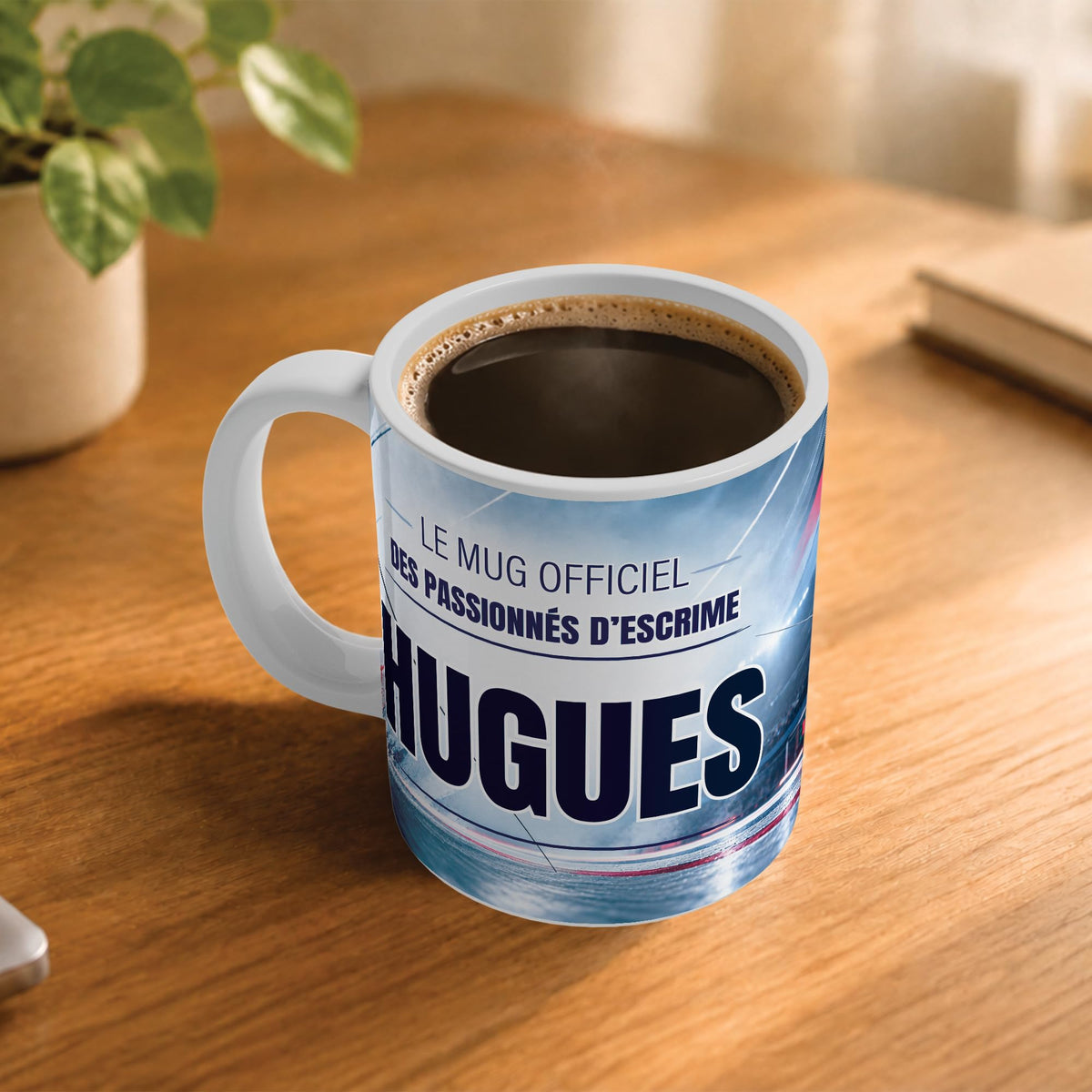 Café fumant dans le mug escrime posé sur un bureau en bois : la phrase « Le mug officiel des passionnés d'escrime » et son prénom en grandes capitales, mug livré chez vous (exemple)