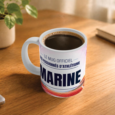 Café fumant dans le mug athlétisme posé sur un bureau en bois : la phrase « Le mug officiel des passionnés d'athlétisme » et son prénom en grandes capitales, mug livré chez vous (exemple)
