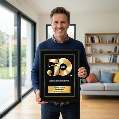 Exemple d'usage : le disque d'or des 50 ans en cadre noir, tenu en souvenir ; son prénom sur le disque, votre signature et un message, livré chez vous (exemple)