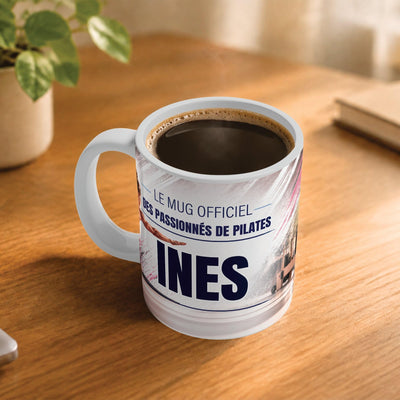 Exemple d'usage : le mug pilates rempli de café sur une table en bois ; 330 ml de céramique blanche, votre prénom imprimé sous le titre, livré à domicile (exemple)