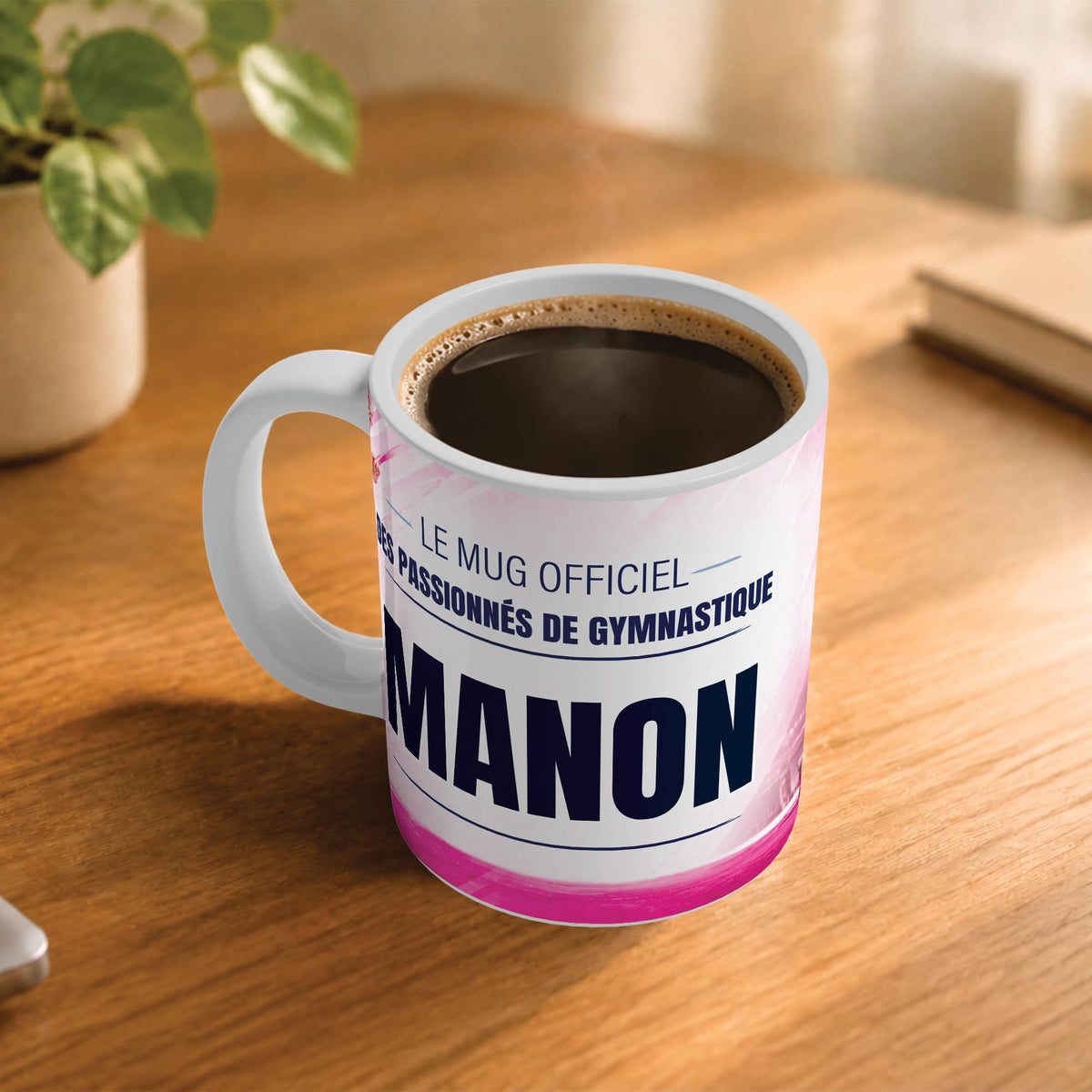 Café fumant dans le mug gymnastique posé sur un bureau en bois : la phrase « Le mug officiel des passionnés de gymnastique » et son prénom en grandes capitales, mug livré chez vous (exemple)