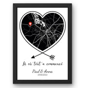 Affiche couple : carte noire aux routes blanches dans un cœur cerné de noir sur fond blanc, flèches croisées, épingle rouge, phrase, prénoms et date, en cadre noir livrée chez vous (exemple)