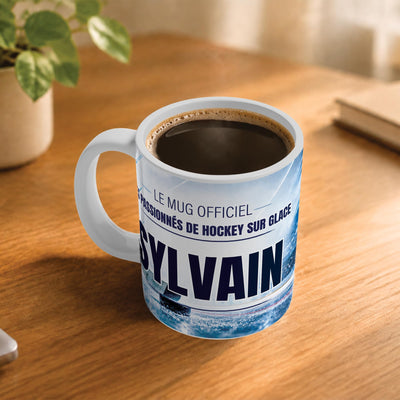 Café fumant dans le mug hockey sur glace posé sur un bureau en bois : la phrase « Le mug officiel des passionnés de hockey sur glace » et son prénom en grandes capitales, mug livré chez vous (exemple)
