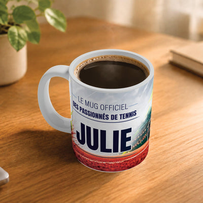 Exemple d'usage : le mug tennis femme rempli de café sur une table en bois ; 330 ml de céramique blanche, votre prénom imprimé sous le titre, livré à domicile (exemple)