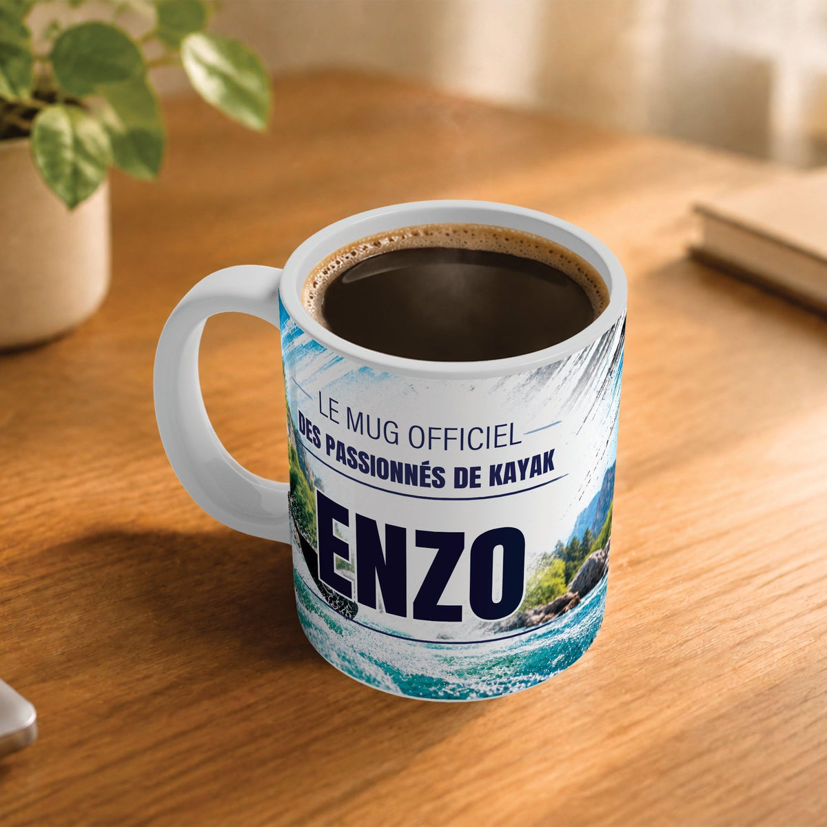 Café fumant dans le mug kayak posé sur un bureau en bois : la phrase « Le mug officiel des passionnés de kayak » et son prénom en grandes capitales, mug livré chez vous (exemple)