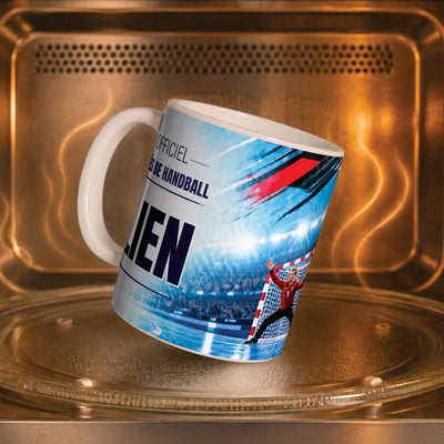 Mug handball dans un four à micro-ondes, on y voit le gardien et sa cage : compatible micro-ondes, aussi en version magique révélée par la chaleur ; livré chez vous (exemple)