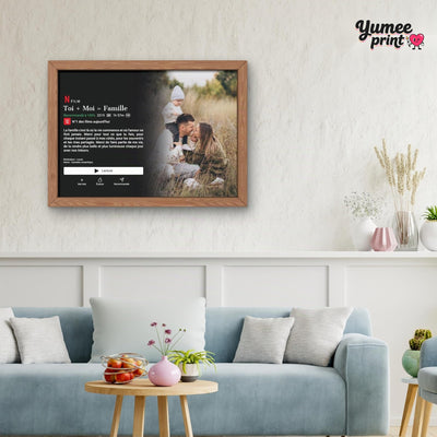 Affiche façon écran de streaming en cadre bois au mur d'un salon : la photo que vous envoyez devient un film à votre titre, imprimée et livrée chez vous (exemple)